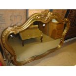 A large shaped gilt framed wall mirror.