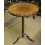 A 19th century mahogany tripod table, the top having pierced brass gallery on a fluted column.