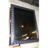 A modern carved and stained framed bevelled edge wall mirror.