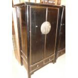 A Oriental black lacquered 2-door cupboard with drawers under.