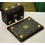 A domed top leather covered stationery cabinet and matching desk blotter.