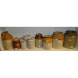 A shelf of various Stoneware jars and a flagon.