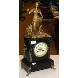 A slate and marble mantel clock surmounted by a gilded spelter figure.