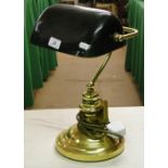 Adjustable brass desk lamp with green shade.