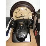 A Smith's Bakelite wall clock and a black Bakelite dial phone.