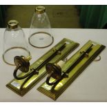 A pair of brass wall lights with shades.