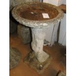 A weathered concrete garden bird bath.