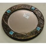 An Arts & Crafts circular mirror with embossed metal frame and Ruskin Pottery inserts.