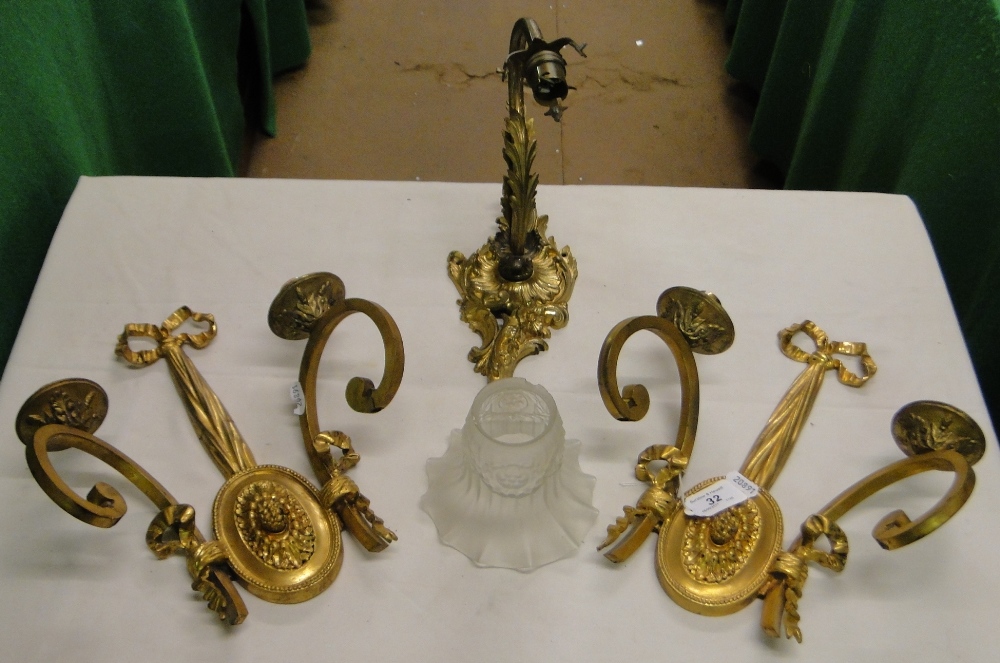 A pair of cast gilt brass twin branch wall lamps and another.