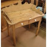 An Antique pine wash stand, with raised shaped back, 2 frieze drawers on tapered legs.