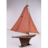 A large Gamages wooden hulled Vintage pond yacht, with sails and rigging on stand,