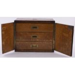 A Victorian oak table cabinet, 2 doors enclosing 3 drawer interior with recessed brass handles,