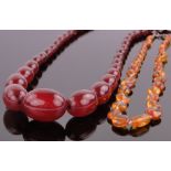 A string of graduated cherry amber beads, largest bead length 28mm,