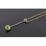 An Edwardian 9ct gold 2 stone peridot drop pendant and chain, pendant length 42mm,