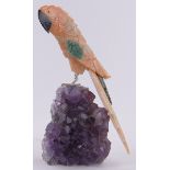 An unusual carved multi-colour hardstone ornamental parrot, on natural amethyst base,