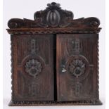 A small 19th century carved and stained beech 2-door cupboard,