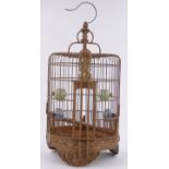 A Chinese carved wood bird cage, with porcelain water pots.