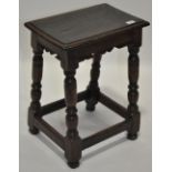 A 17th century oak joint stool, scroll carved frieze and baluster turned supports, length 18",