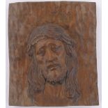 A relief carved and stained wood wall plaque, depicting the head of Christ, 34cm x 29cm.