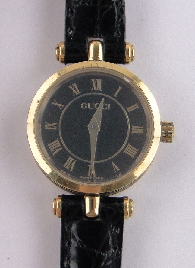 A lady's Gucci 2040L quartz wristwatch, gold plated case with black dial, case width 22mm.