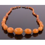 A string of graduated butterscotch amber beads, largest bead length 23mm, gross weight 33.6g.