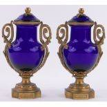 A pair of early 19th century ormolu and Bristol blue glass urns and covers,