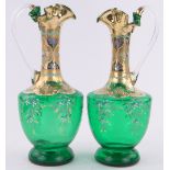 A pair of Bohemian green glass wine ewers, painted and gilded decoration with frilled rims,