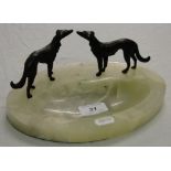 An onyx dish surmounted by 2 bronze hounds.