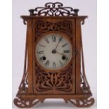 A French Art Nouveau stained wood fretwork cased mantel clock, 8-day striking movement,