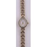 A lady's 9ct gold cased Rotary quartz wristwatch, diamond set bezel with 9ct strap, case width 13mm.