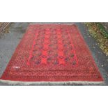 A large red ground Turkey rug, with symmetrical borders and central gul decorated panel,