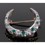 An emerald and diamond crescent shaped brooch, 9ct gold settings, diameter 24mm.