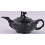 An Oriental relief carved black stone teapot, with carved floral knop, length 17cm.