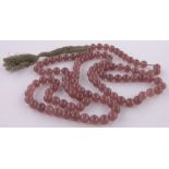 A long string of Chinese pink hardstone beads, diameter 14cm.