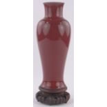 A Chinese copper red glaze porcelain vase, height 28cm on carved hardwood stand.