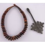 An Ethiopian bronze hand cross, length 18cm and a string of Oriental graduated horn beads.