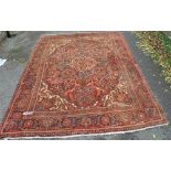 An Antique red ground Persian rug with symmetrical pattern and border, 10'8" x 7'8".