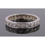 A diamond set eternity ring, unmarked white gold settings, band width 3mm, size L.