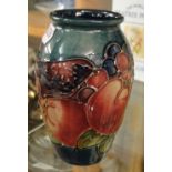 A small Moorcroft blue ground vase with bird and fruit decoration.