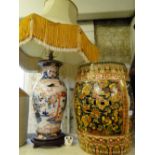 An Oriental painted and gilded garden seat and a table lamp and shade.