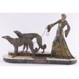 An Art Deco bronze patinated spelter and ivorine sculpture in the form of a lady with 2 Borzoi dogs,