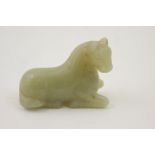 Chinese carved jade figure of a recumbent horse, 19th Century, uniform celadon green,