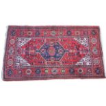 Hamadan woollen rug, red field with a central blue pole medallion,