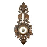Swiss carved limewood aneroid barometer, circa 1900, carved throughout with bold leaves,