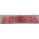 Qashqai woollen runner, red field with blue and fawn medallions in a flowerhead border, size approx.
