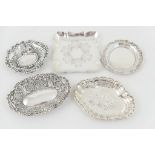 Four various silver bonbon dishes and a coaster including a lobed oval example,
