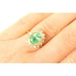 Emerald and diamond cluster ring, the oval cut emerald of approx.