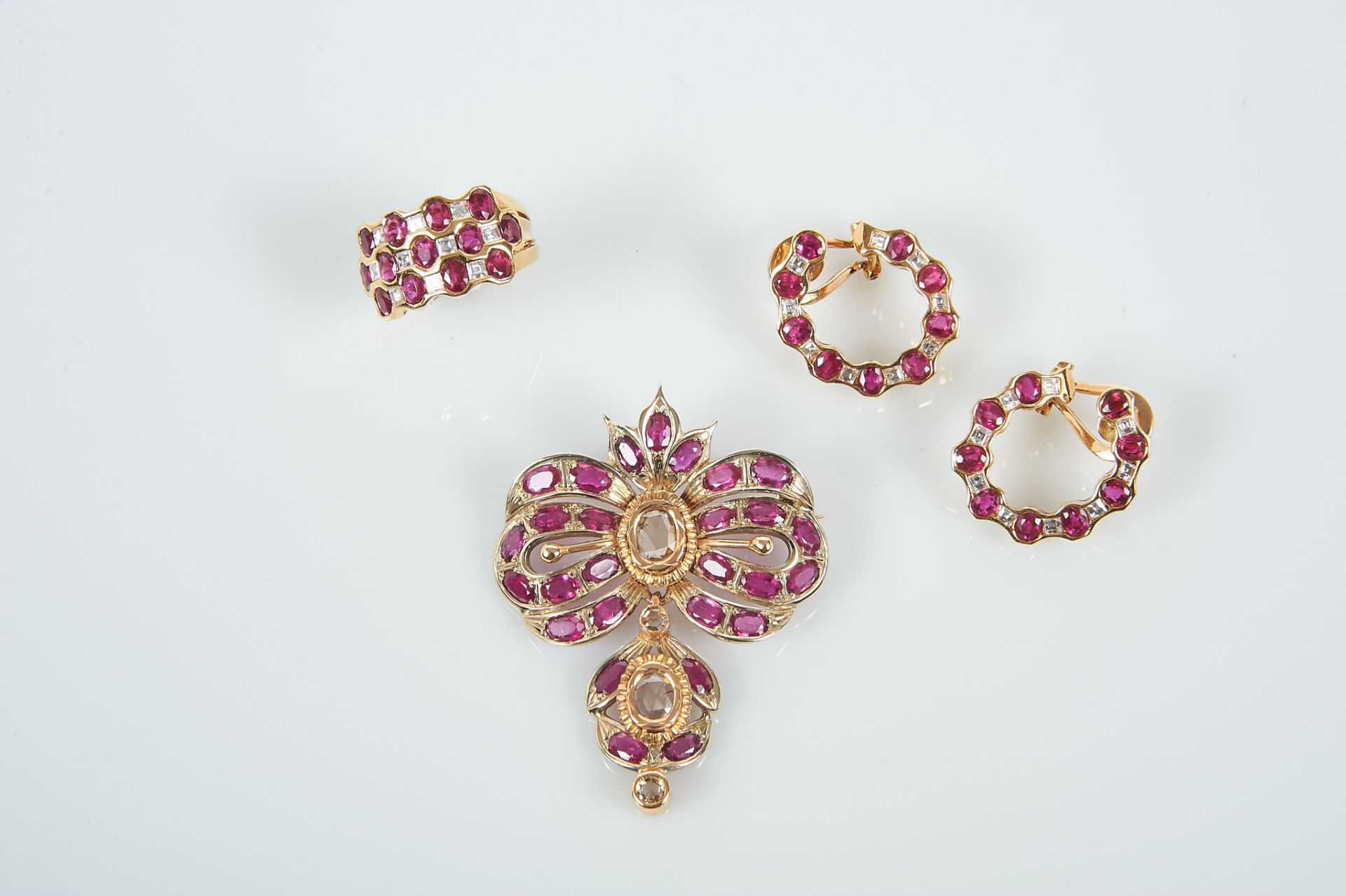 A Ring and a Pair of Earrings, 800/1000 gold, set with 31 oval cut rubies with the approximate