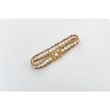 A Bracelet, 750/1000 gold, interspersed with 29 culture pearls (5,5 mm) and engraved clasp set