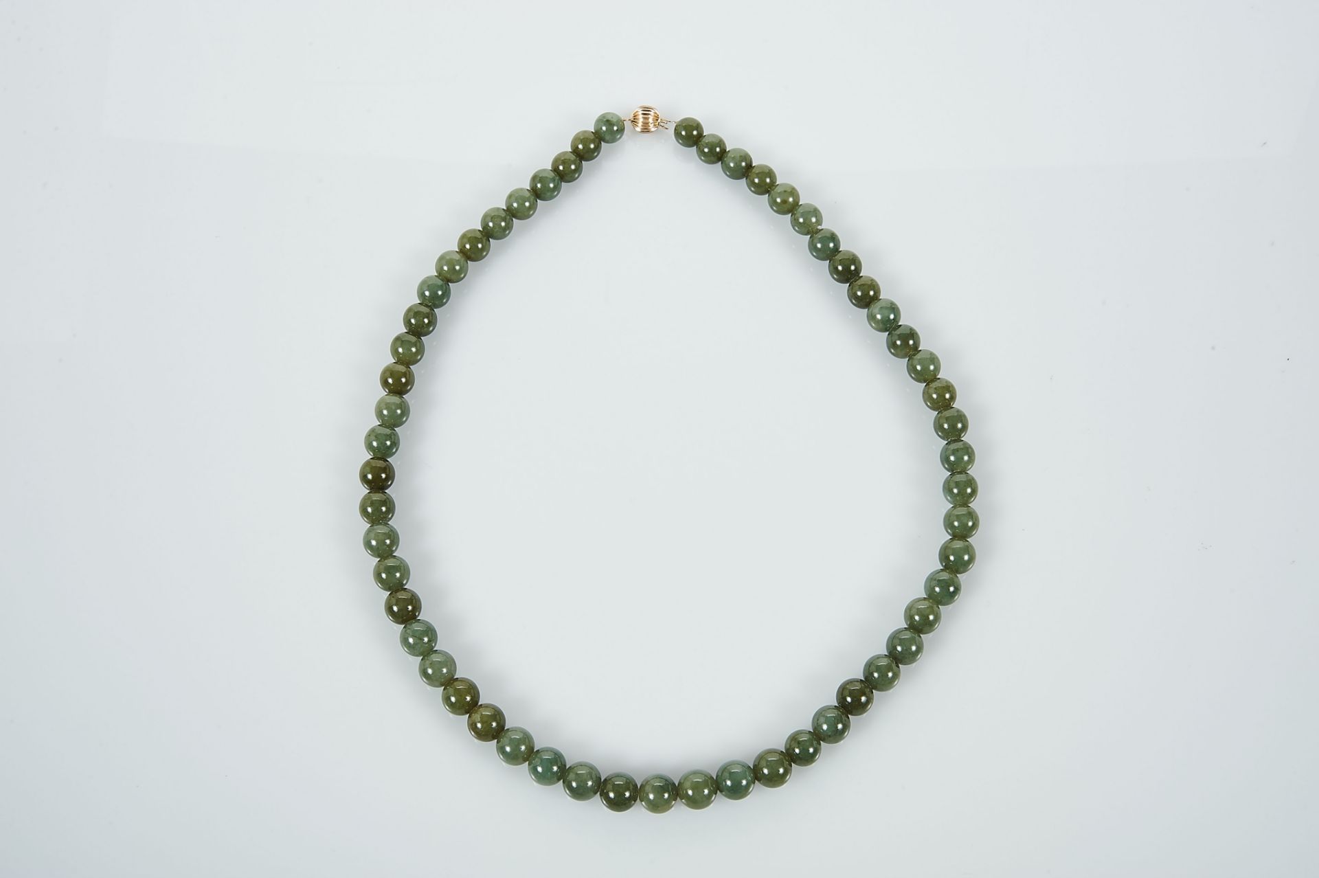 A Necklace, a string of 56 Jadeite beads (9 mm), gadrooned 14 kt. gold clasp, marked, Dim. - 57,5 - Bild 2 aus 3